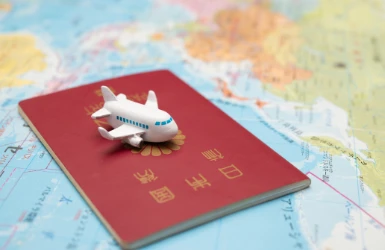 Japanischer Pass und Spielzeugflugzeug auf einer Landkarte