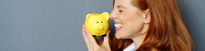 Frau freut sich über gelbes Sparschwein