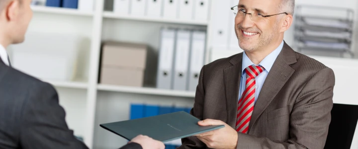 Geschäftsmann überreicht seine Bewerbungsmappe