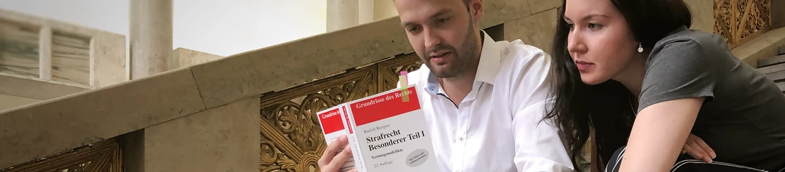 Studenten lesen im Strafrechtslehrbuch