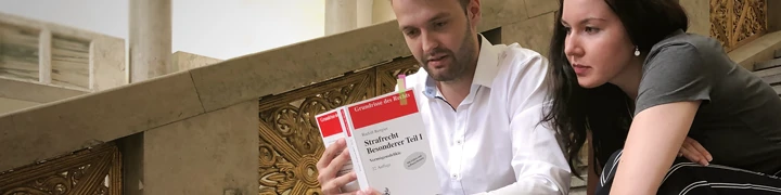 Studenten lesen im Strafrechtslehrbuch