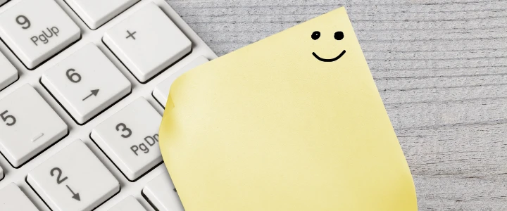 Notizzettel mit Smiley auf Tastatur