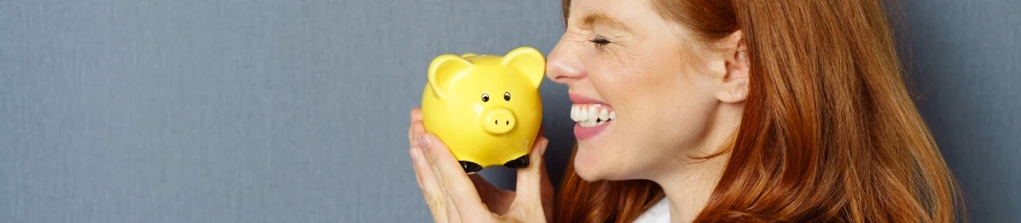 Frau freut sich über gelbes Sparschwein