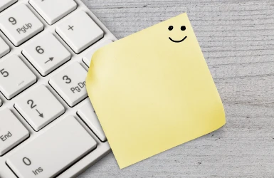 Notizzettel mit Smiley auf Tastatur