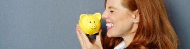 Frau freut sich über gelbes Sparschwein