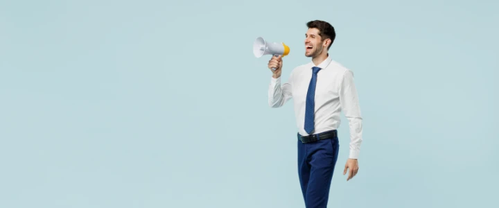 Mann mit Hemd und Krawatte ruft ins Megafon