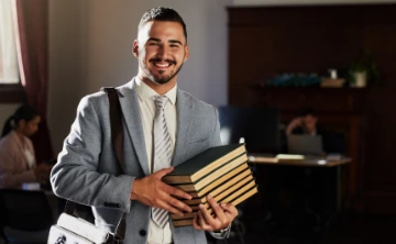 Junger Jurastudent mit Büchern in der Hand