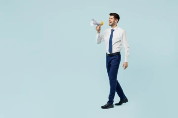 Mann mit Hemd und Krawatte ruft ins Megafon