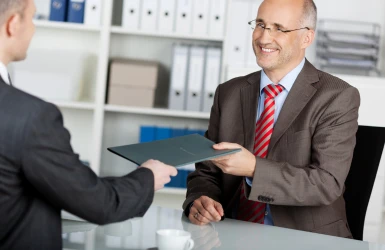 Geschäftsmann überreicht seine Bewerbungsmappe