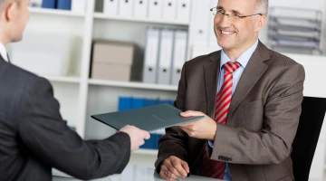 Geschäftsmann überreicht seine Bewerbungsmappe