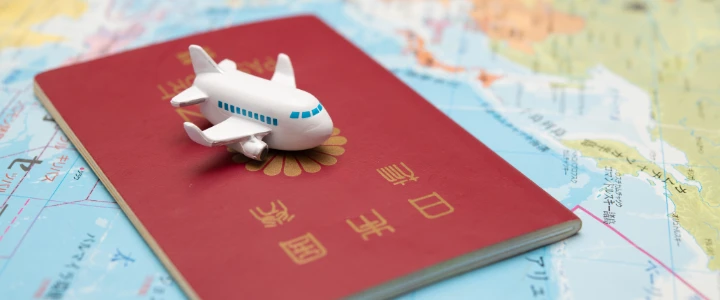 Japanischer Pass und Spielzeugflugzeug auf einer Landkarte